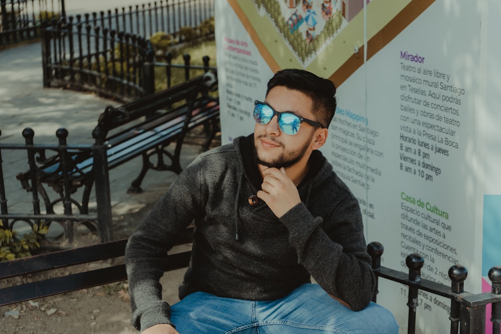 woman in gray sweater and blue denim jeans wearing black sunglasses