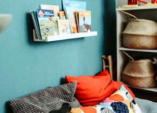 red textile on blue and white bed linen