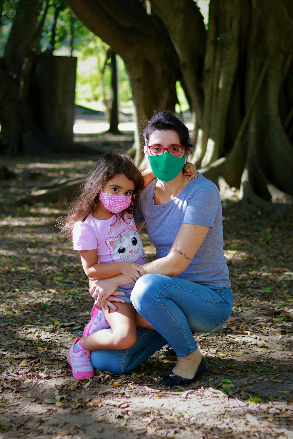 woman in pink t-shirt and blue denim jeans carrying baby in pink shirt