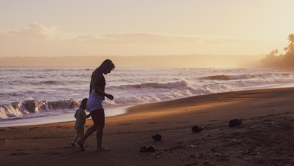 일몰 동안 해변을 걷는 남자와 여자