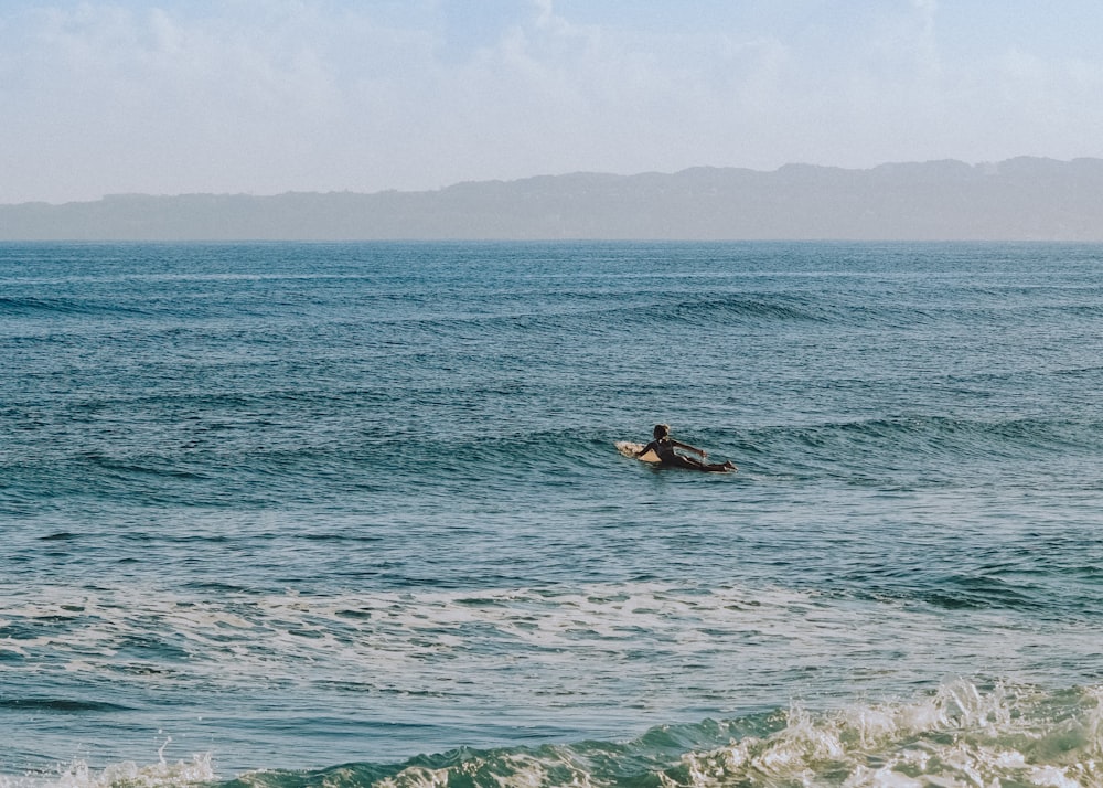 Persona che fa surf sul mare durante il giorno