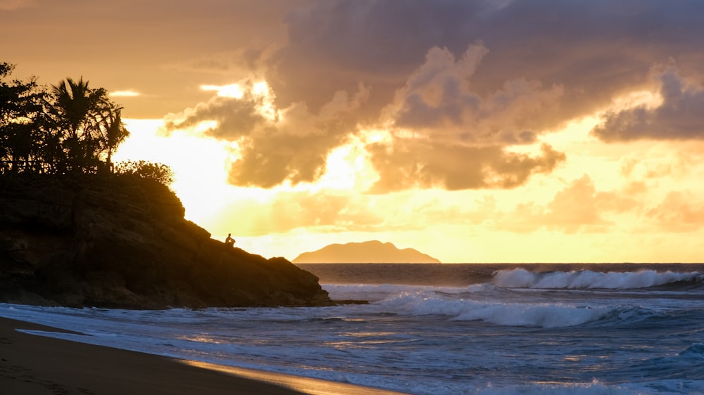 sea waves crashing on shore during sunset