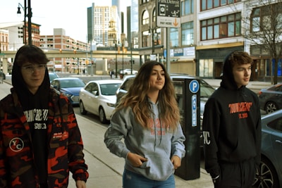Young people wearing oversized urban clothing in a city street setting.
