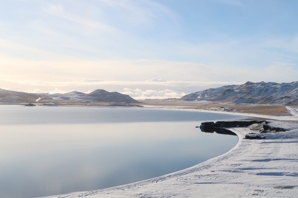 snow covered mountain near body of water during daytime