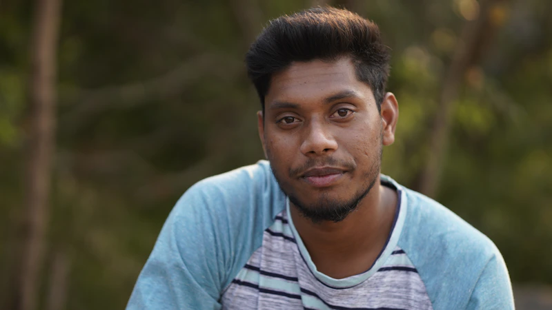 young Indian man in a blue and white shirt