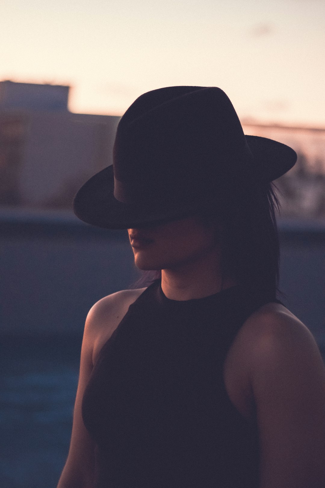 woman in black tank top wearing black fedora hat