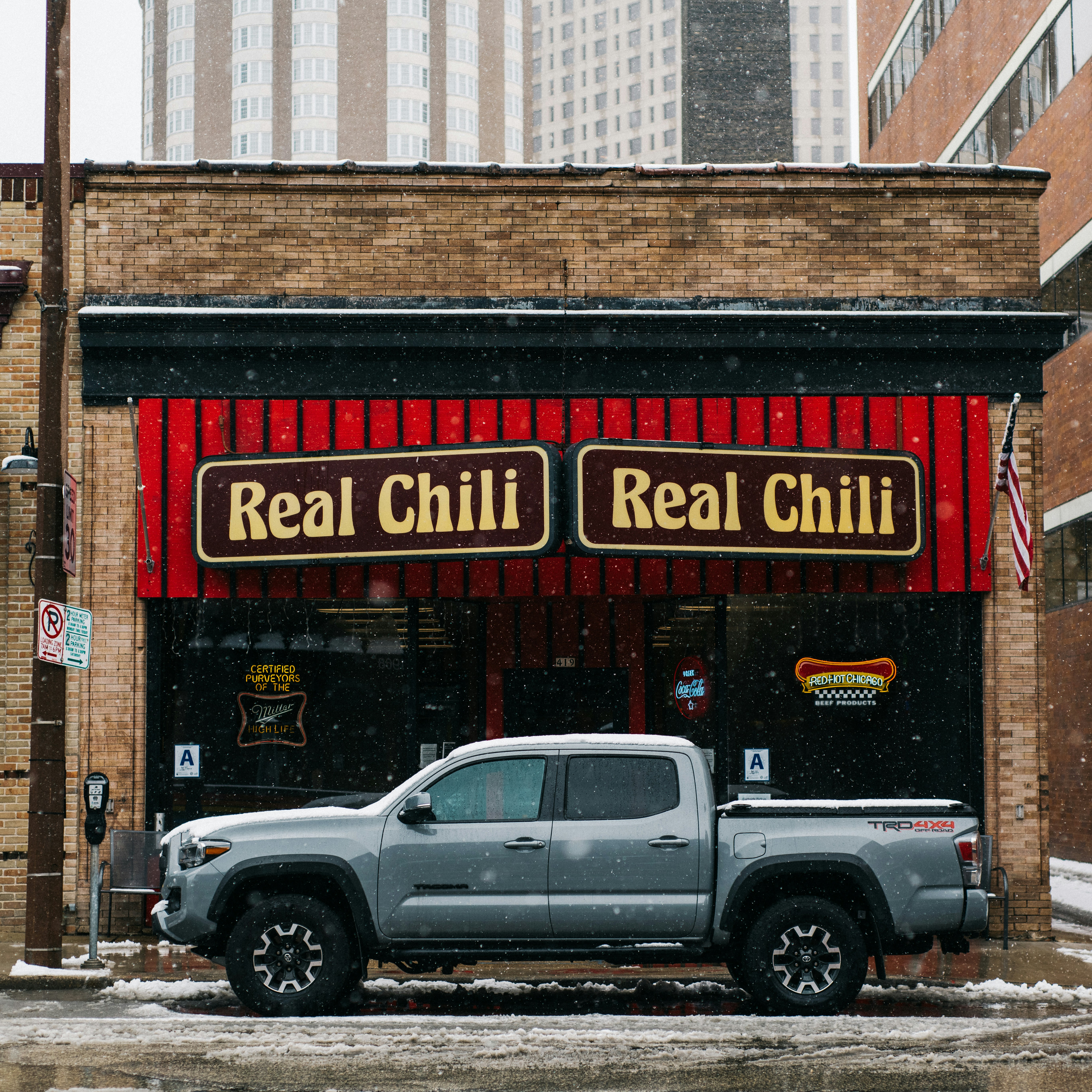 Weißer Doppelkabinen-Pickup-Truck, der tagsüber neben dem braunen Gebäude geparkt ist