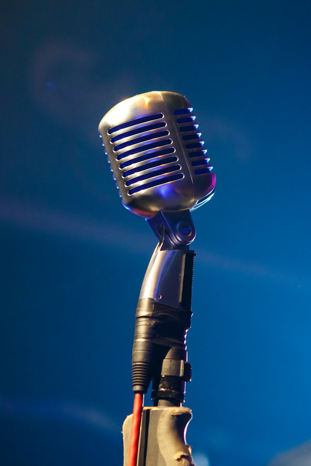 Schwarzes Mikrofon auf blauem Hintergrund