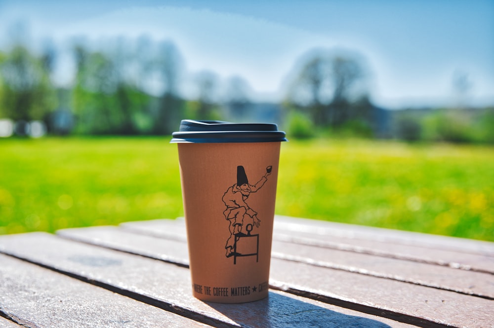 brown and black coffee cup on brown wooden table