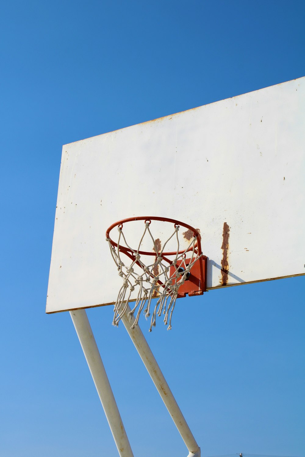 white and red basketball hoop under blue sky during daytime