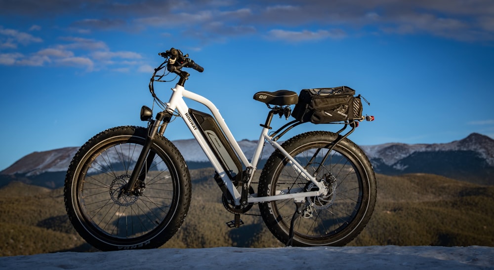 white and black mountain bike on brown field during daytime