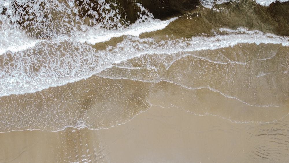 茶色の砂浜に波打つ水