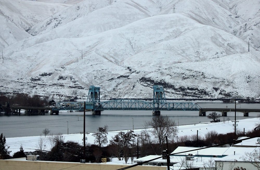 green and white building near snow covered mountain during daytime