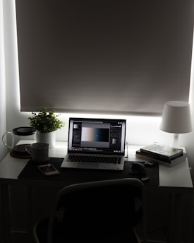 silver macbook pro on brown wooden table