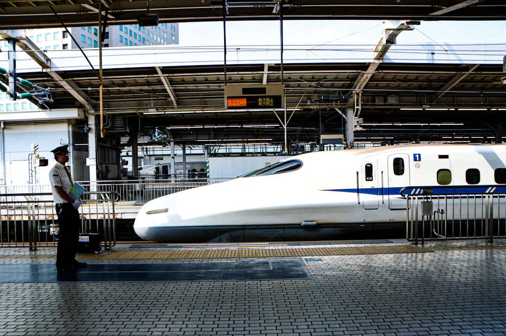 A shinkansen at the platform with a conductor