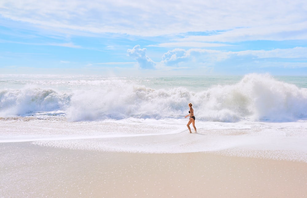 person in black shorts walking on seashore during daytime