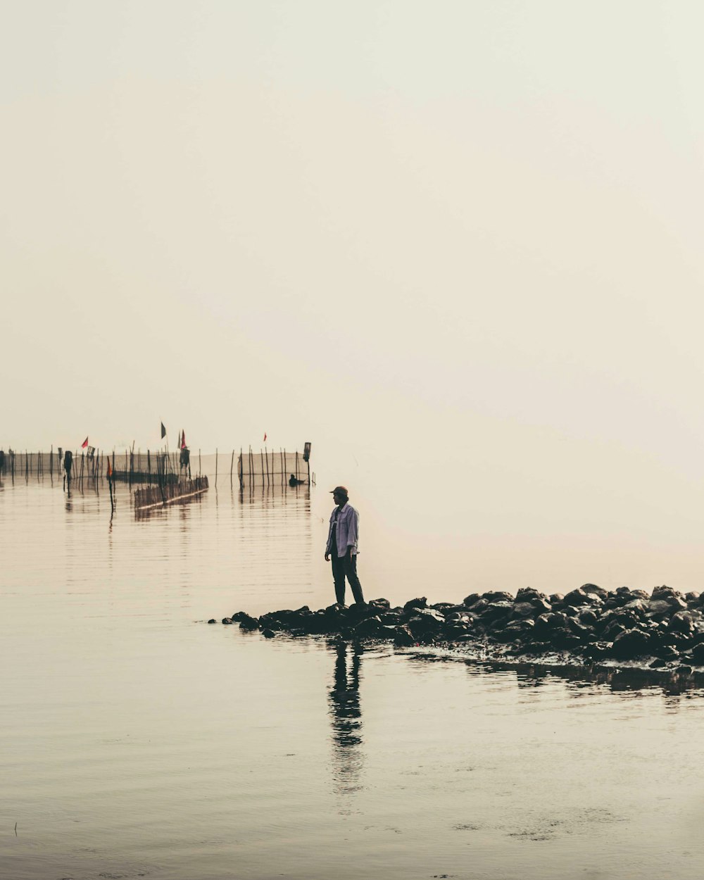 man and woman walking on black rock in the middle of the sea