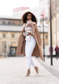 woman in white long sleeve shirt and white pants standing on road during daytime