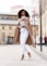 woman in white long sleeve shirt and white pants standing on road during daytime