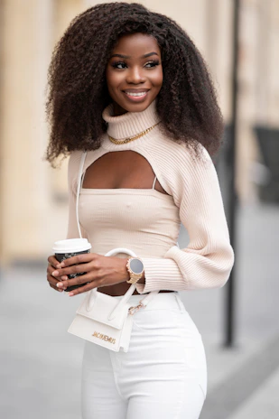 A lifestyle shot of a woman relaxing with a coffee, wearing a cozy sweater and accessorized with a chic watch and handbag.
