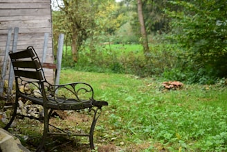 Minimalist metal outdoor bench set against a lush garden backdrop