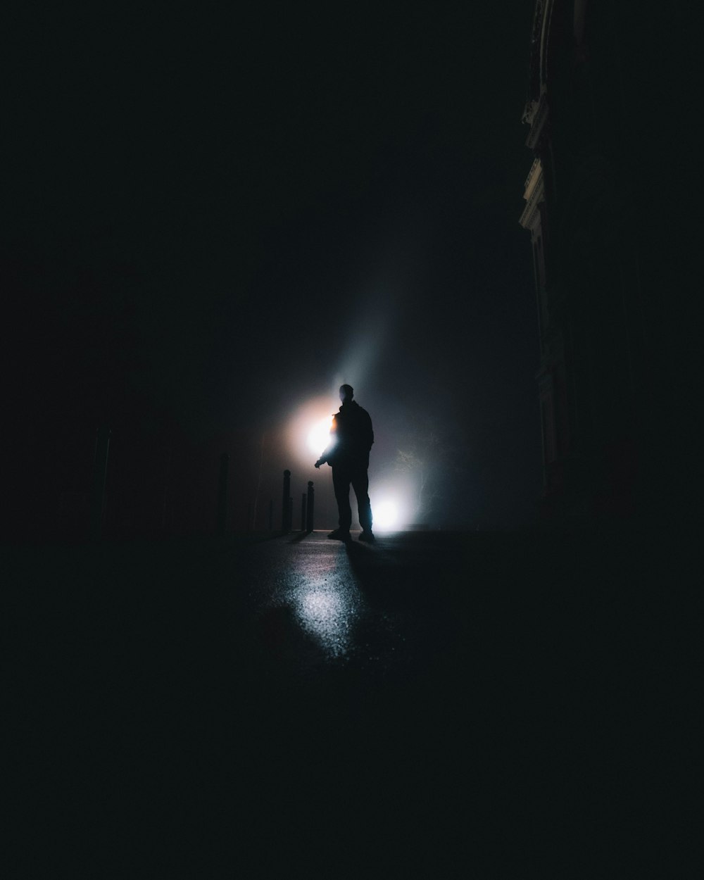 silhouette of person standing in the middle of the dark