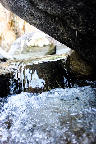 Close-up of mineral water rippling softly in a natural pool surrounded by desert rocks and plants.