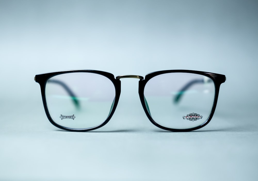 black framed eyeglasses on white surface