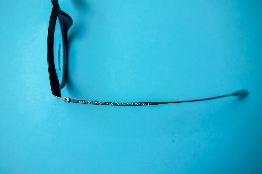 black framed eyeglasses on blue surface