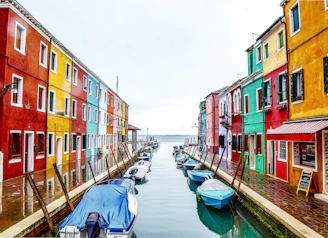 boats on river between buildings during daytime