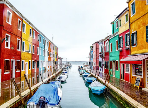 boats on river between buildings during daytime