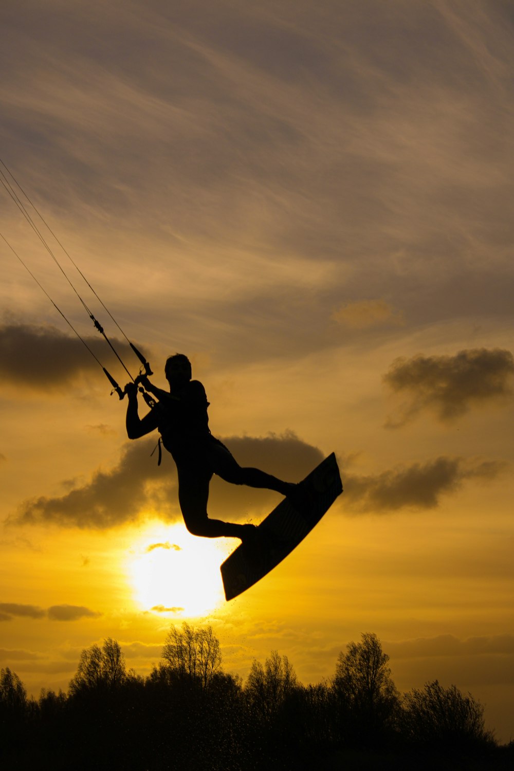 Silhouette eines Mannes, der während des Sonnenuntergangs eine Angelrute hält