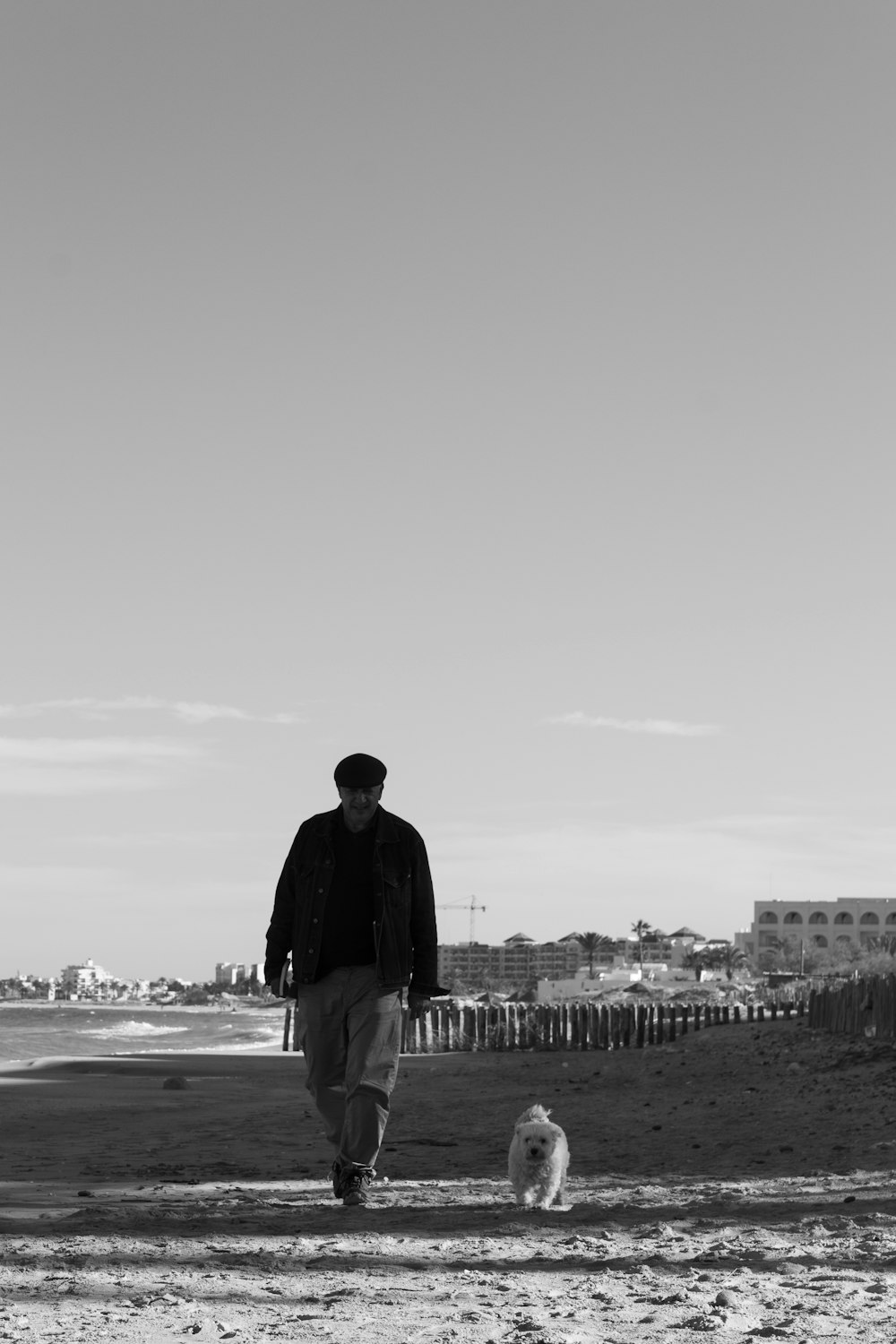 man in black jacket standing on beach during daytime