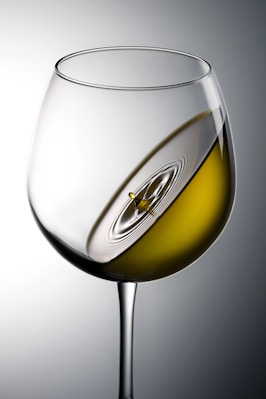clear wine glass with yellow liquid