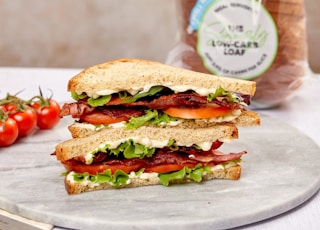 burger with tomato and lettuce on white ceramic plate