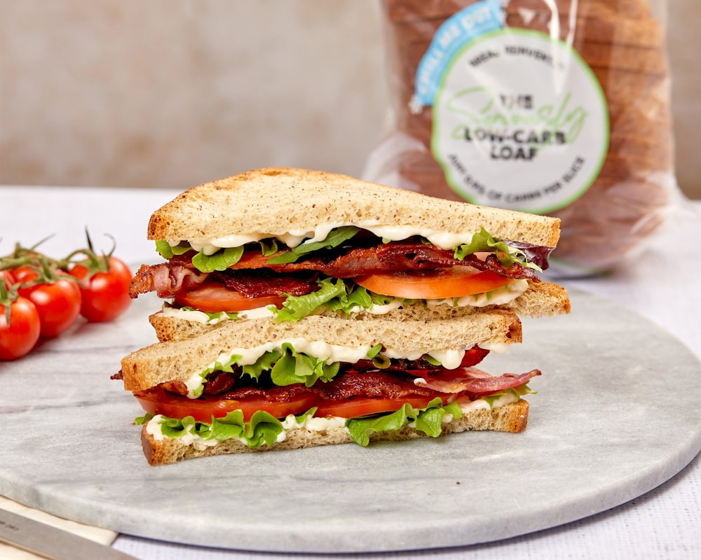 burger with tomato and lettuce on white ceramic plate