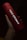 A red cylindrical tumbler featuring the AMD branding held in a hand. The lighting highlights the silver logo and text, creating a contrast against the dark background.