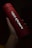 A red cylindrical tumbler featuring the AMD branding held in a hand. The lighting highlights the silver logo and text, creating a contrast against the dark background.
