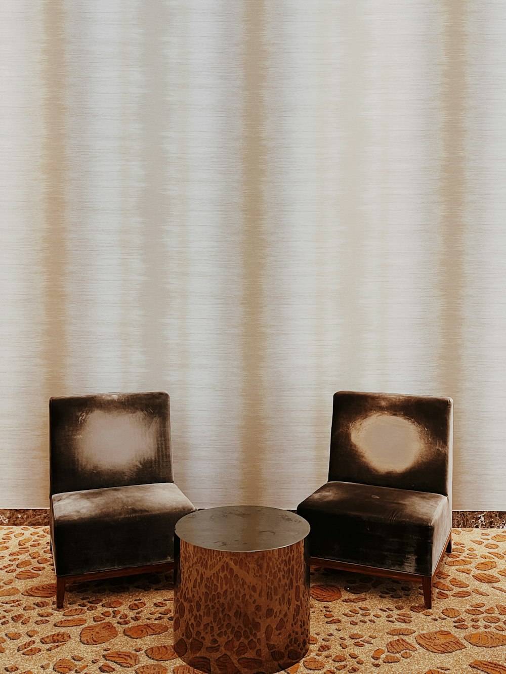 brown wooden round table beside brown and black armchair