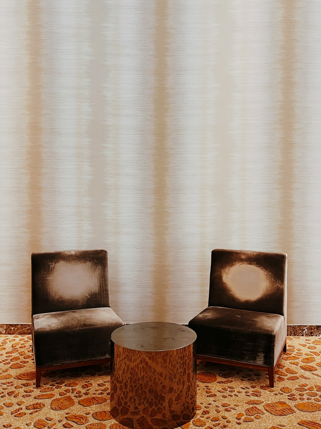 brown wooden round table beside brown and black armchair