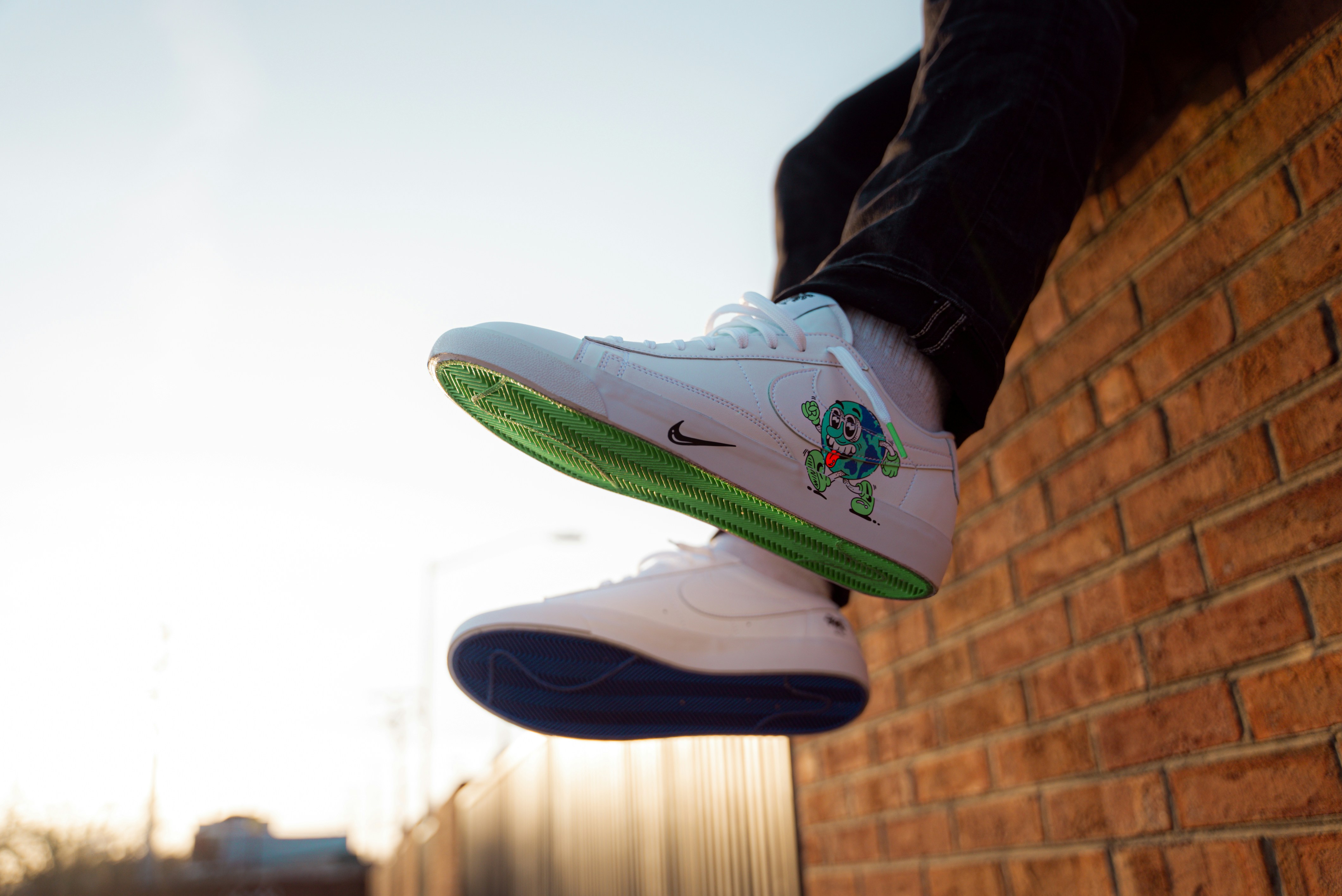 person wearing white and green nike air force 1 high