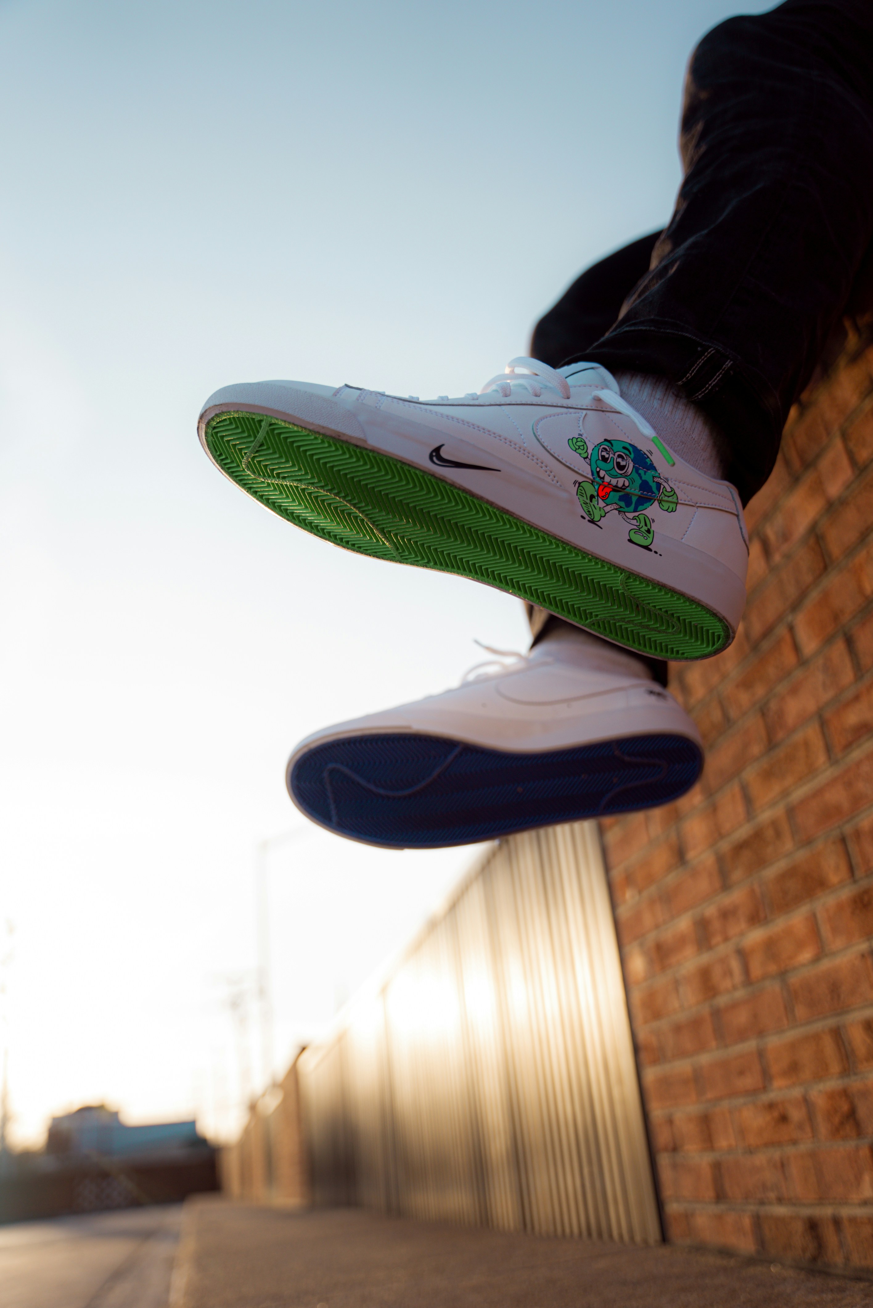 person wearing white and green nike sneakers