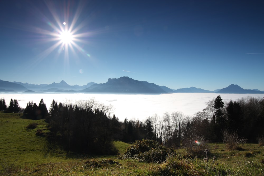 the sun shines brightly over the clouds and mountains