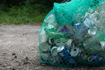 A green mesh bag filled with recyclables.