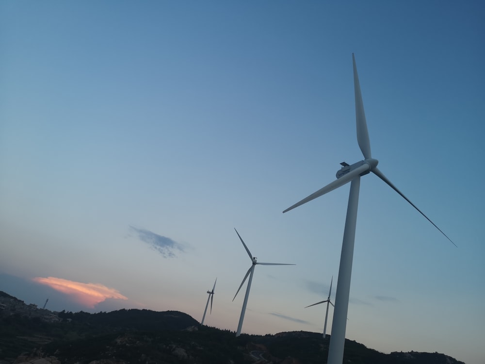 white wind turbine during sunset