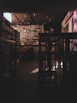 Dimly lit interior of the bar showing the industrial chic decor with matte black and amber gold accents.