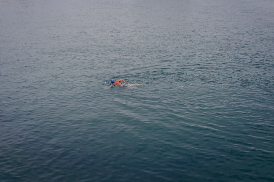 person swimming on blue sea during daytime