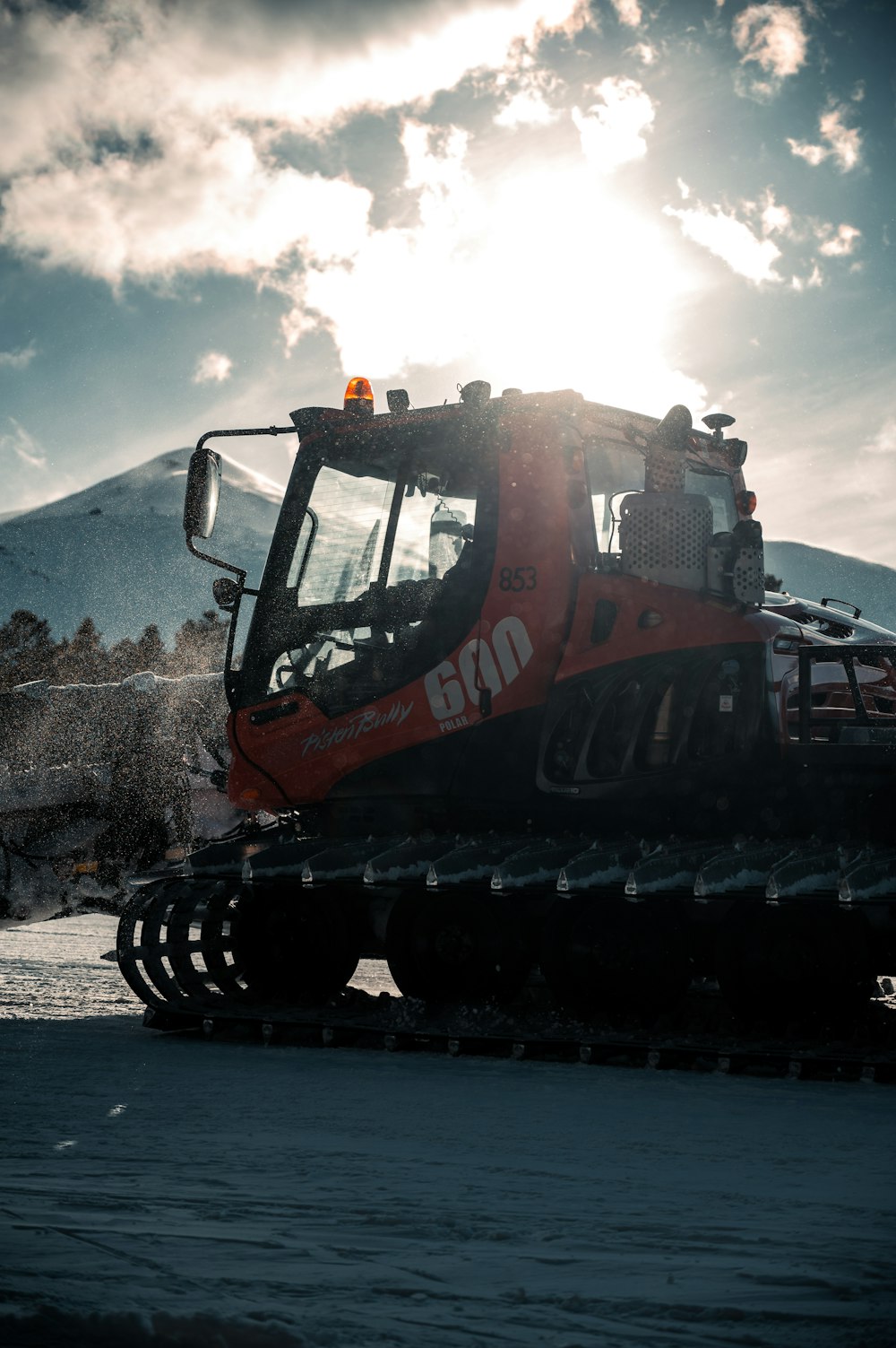orange and black heavy equipment on snow covered ground during daytime