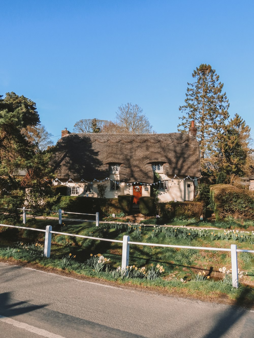 brown wooden house near green trees under blue sky during daytime