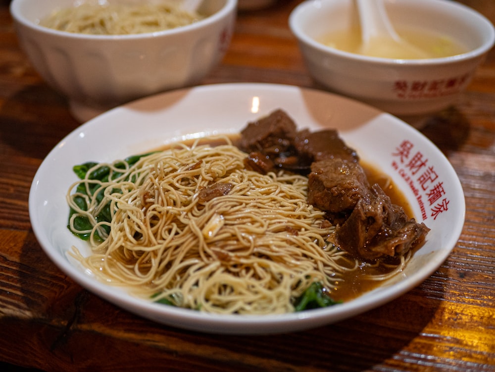 white pasta with meat on white ceramic bowl